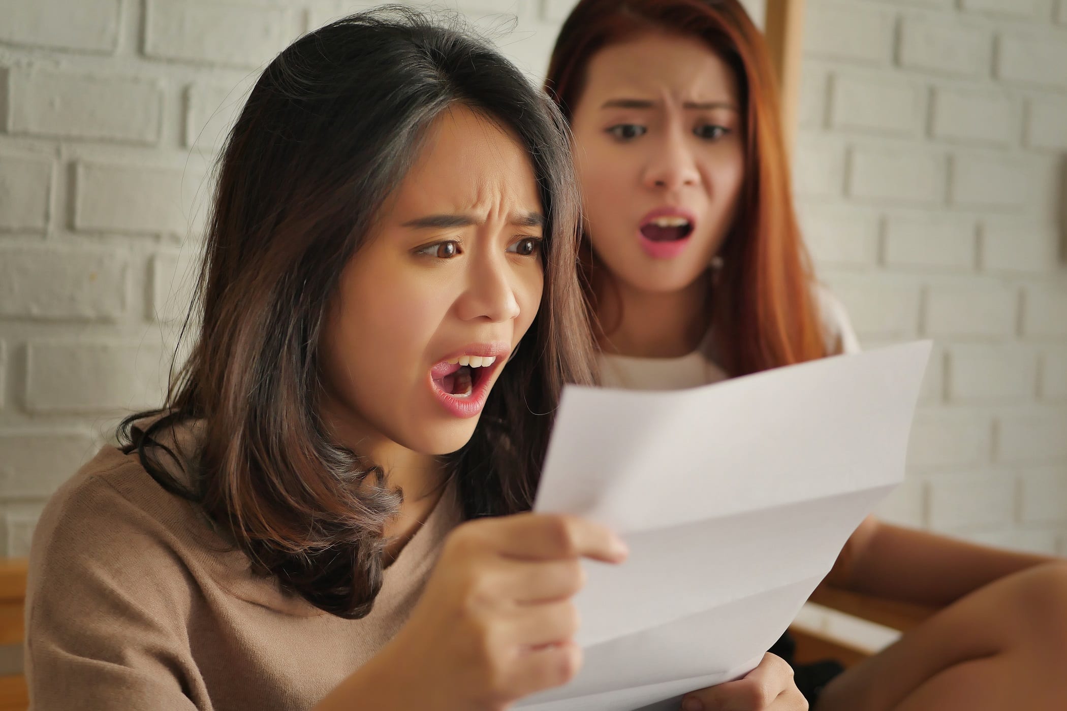 Shocked-women-looking-at-debt-notice-invoice