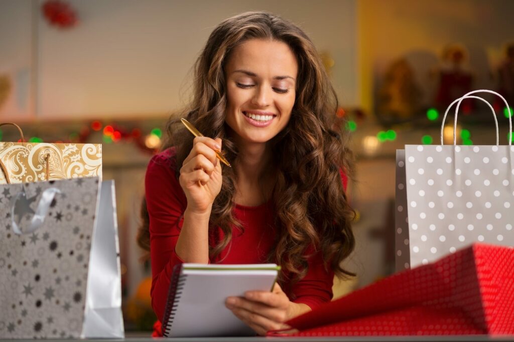 Woman among shopping bags checking list