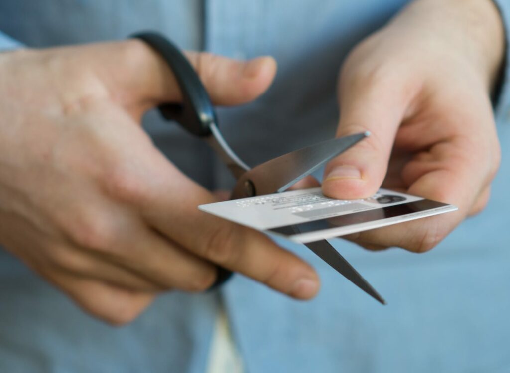 Man Cutting Credit Card With Scissors