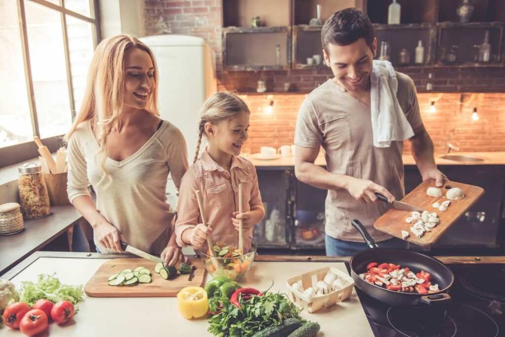 smiling family cooking in kitchen at home