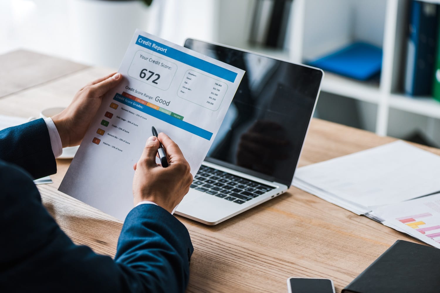 man holding pen near paper with credit report letters