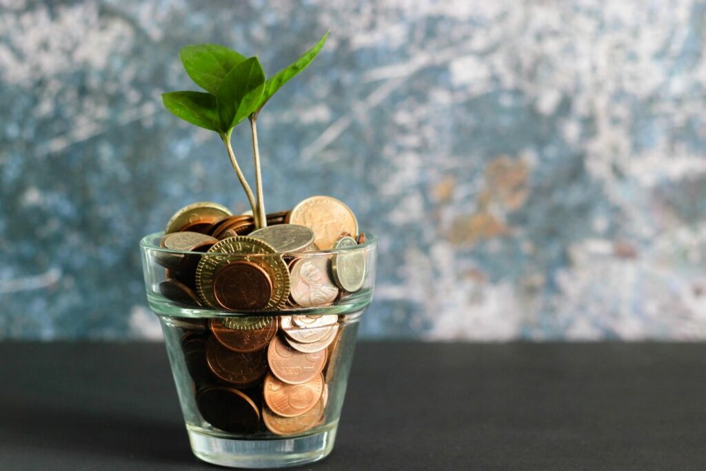 Coin in glass jar and Plant growing with savings money