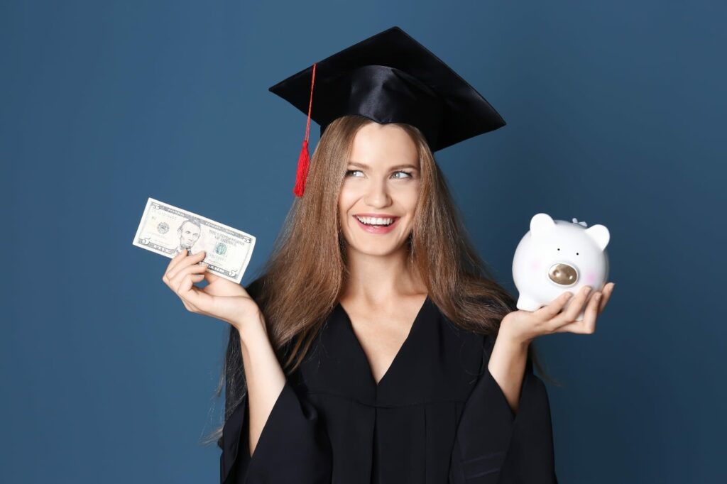 Young graduate with piggy bank