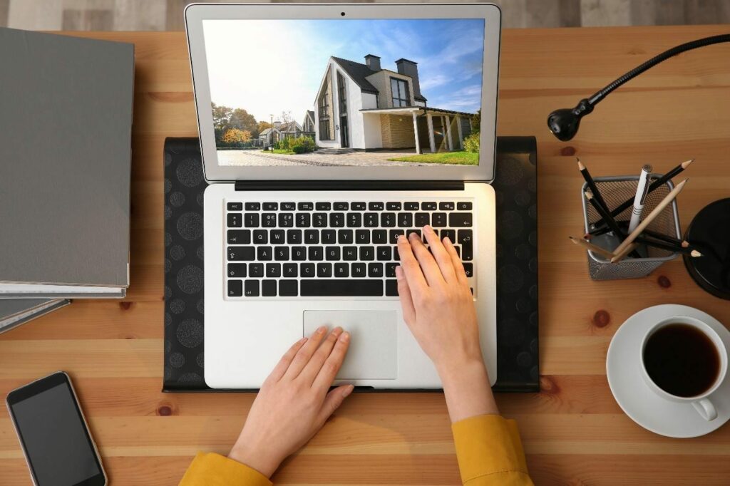 Woman choosing new house online using laptop