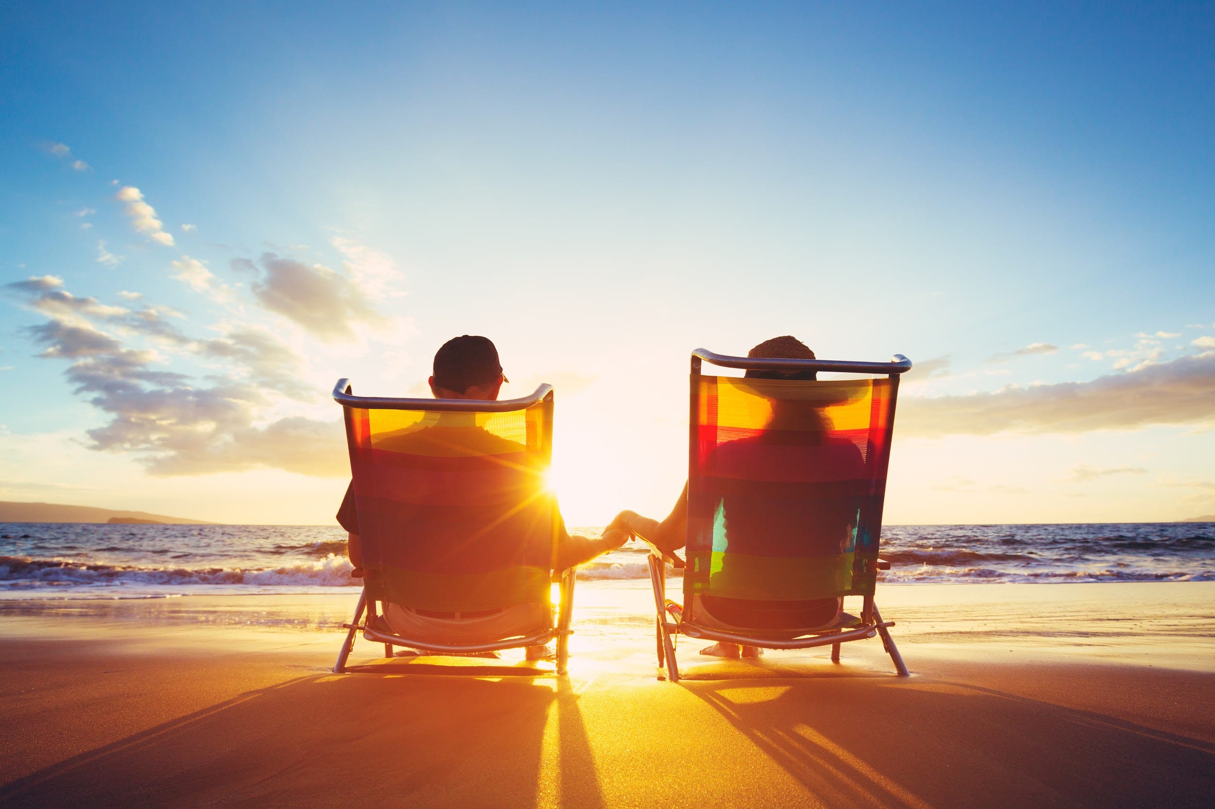 Happy Mature Retired Couple Enjoying Beautiful Sunset at the Beach