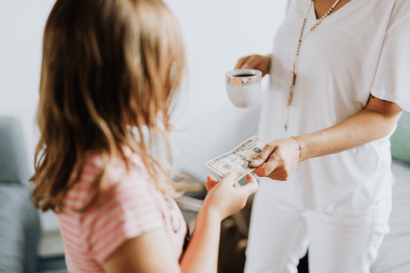 Mother giving child money