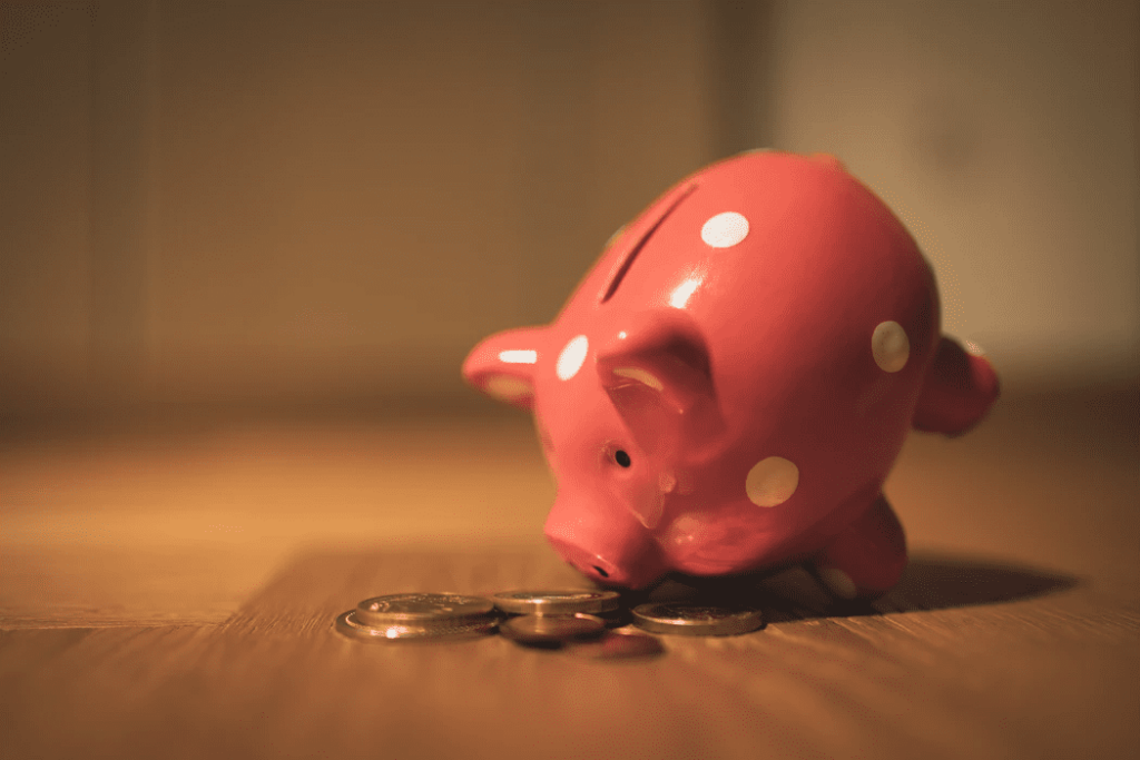 piggy bank with coins on wooden table