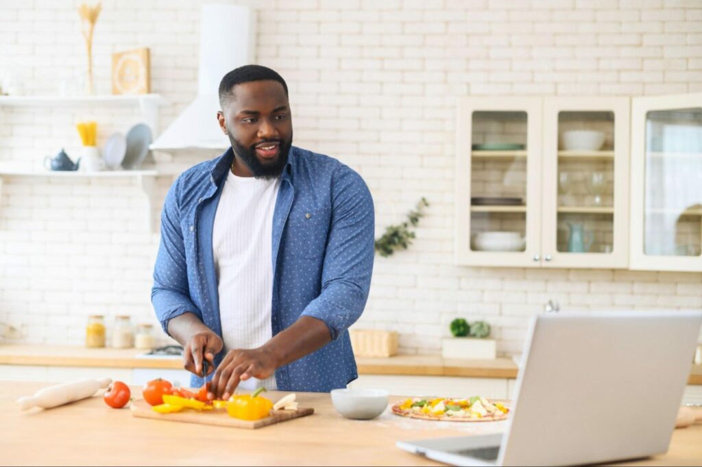 man cutting vegetables in kitchen