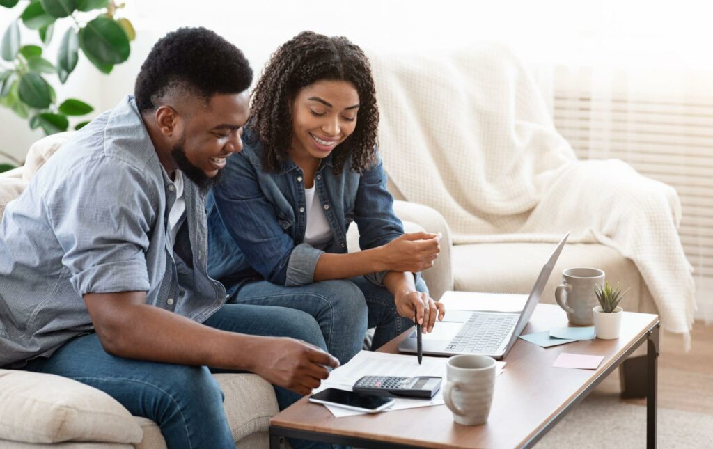 black man and woman calculating expenses togther online