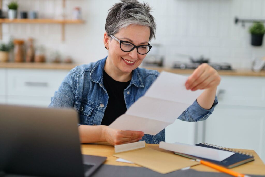 mature woman in glasses reading the bill