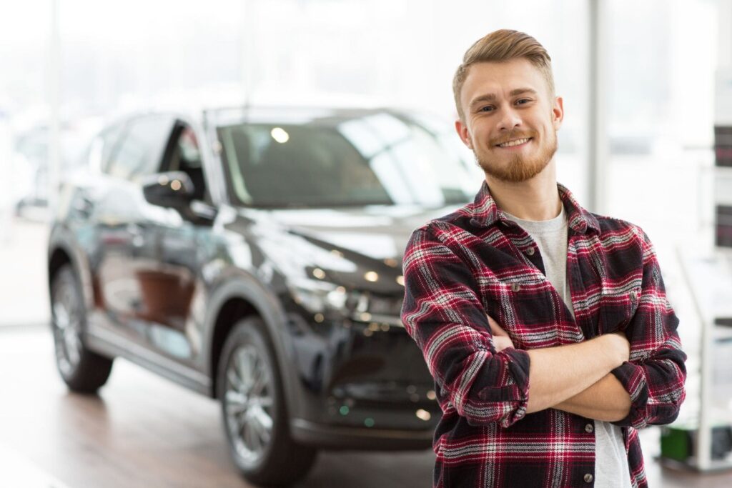 Happy handsome man buying a new car