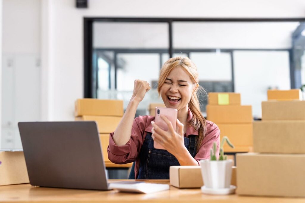 Happy young asian woman entrepreneur, Smile for sales success after checking order