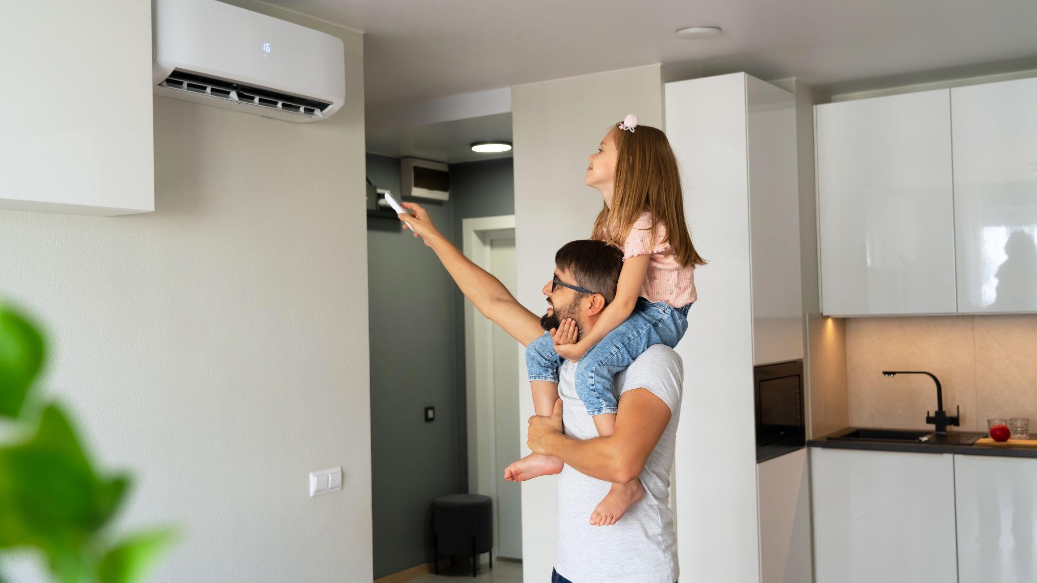 Man and daughter turning on air conditioning