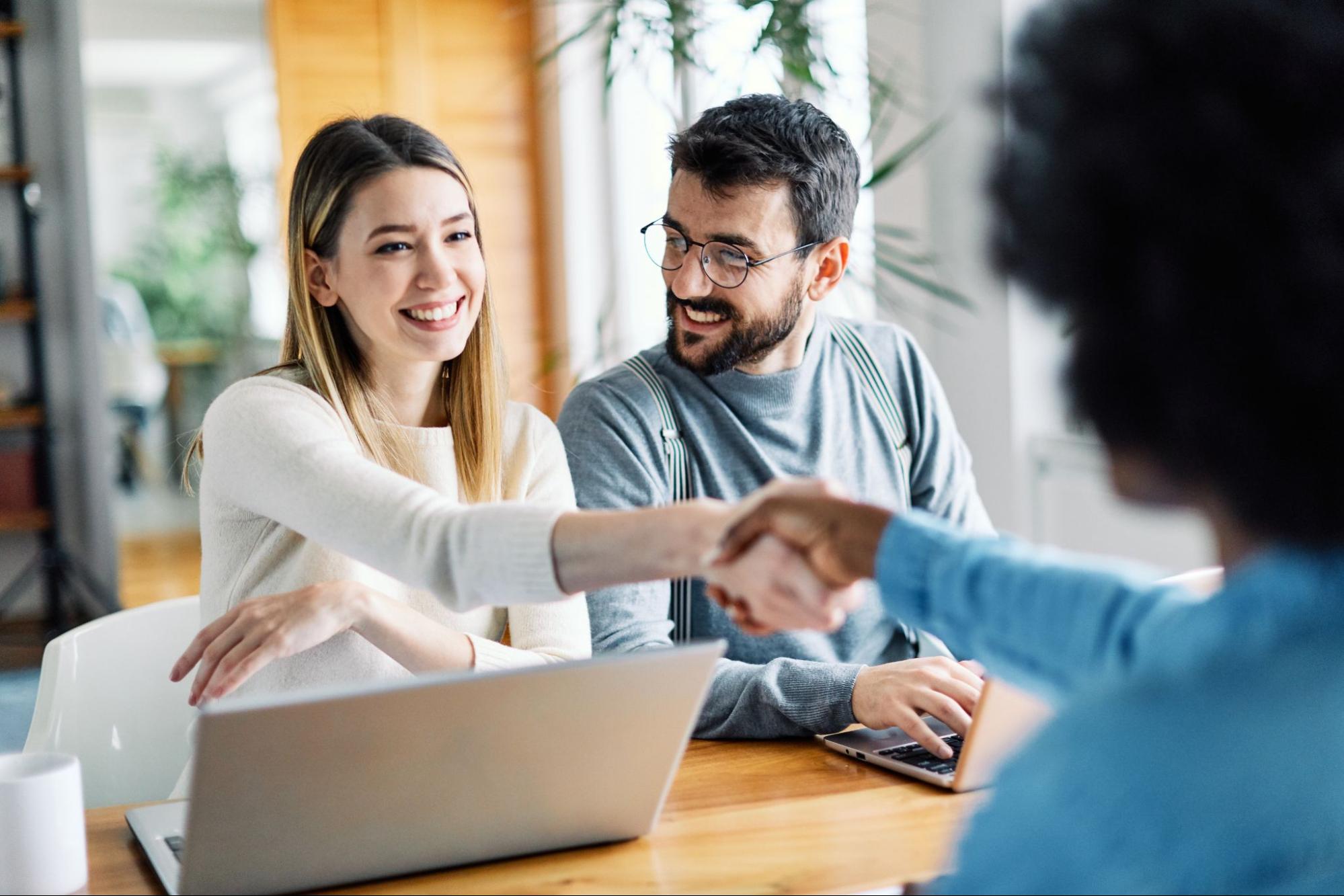 A couple shaking hands with a banker
