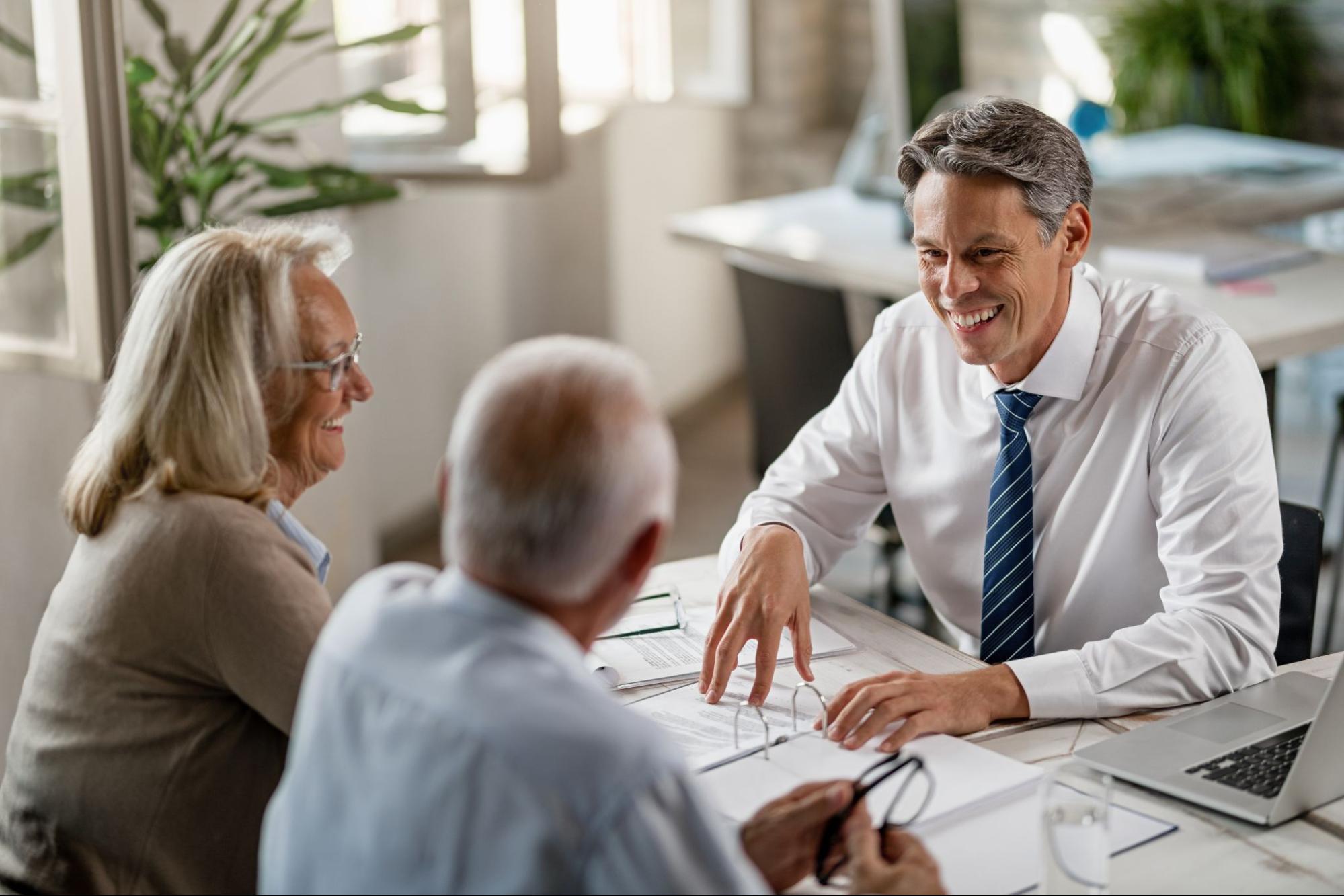 An older couple signing papers at a bank