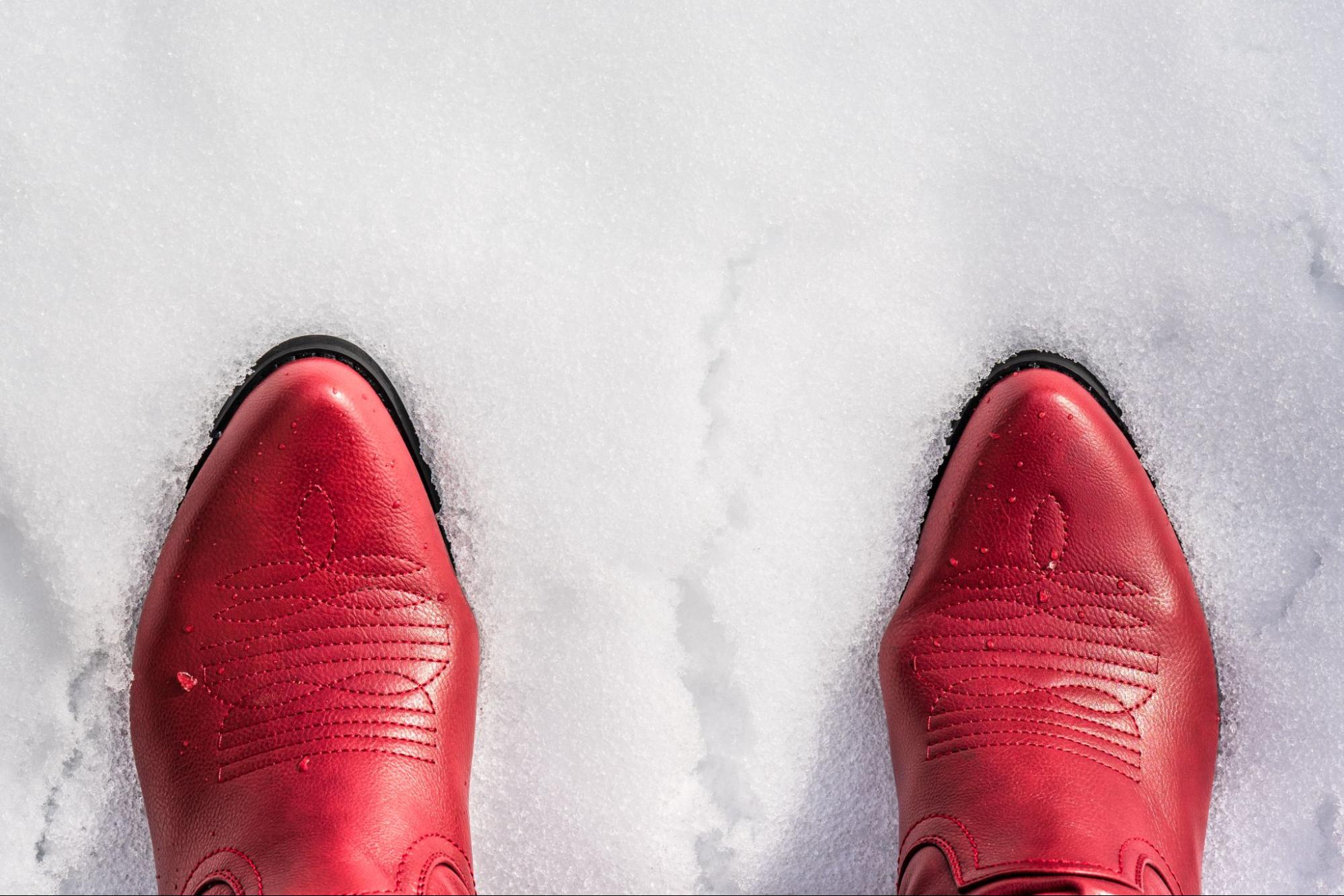 Red cowboy boots standing in snow